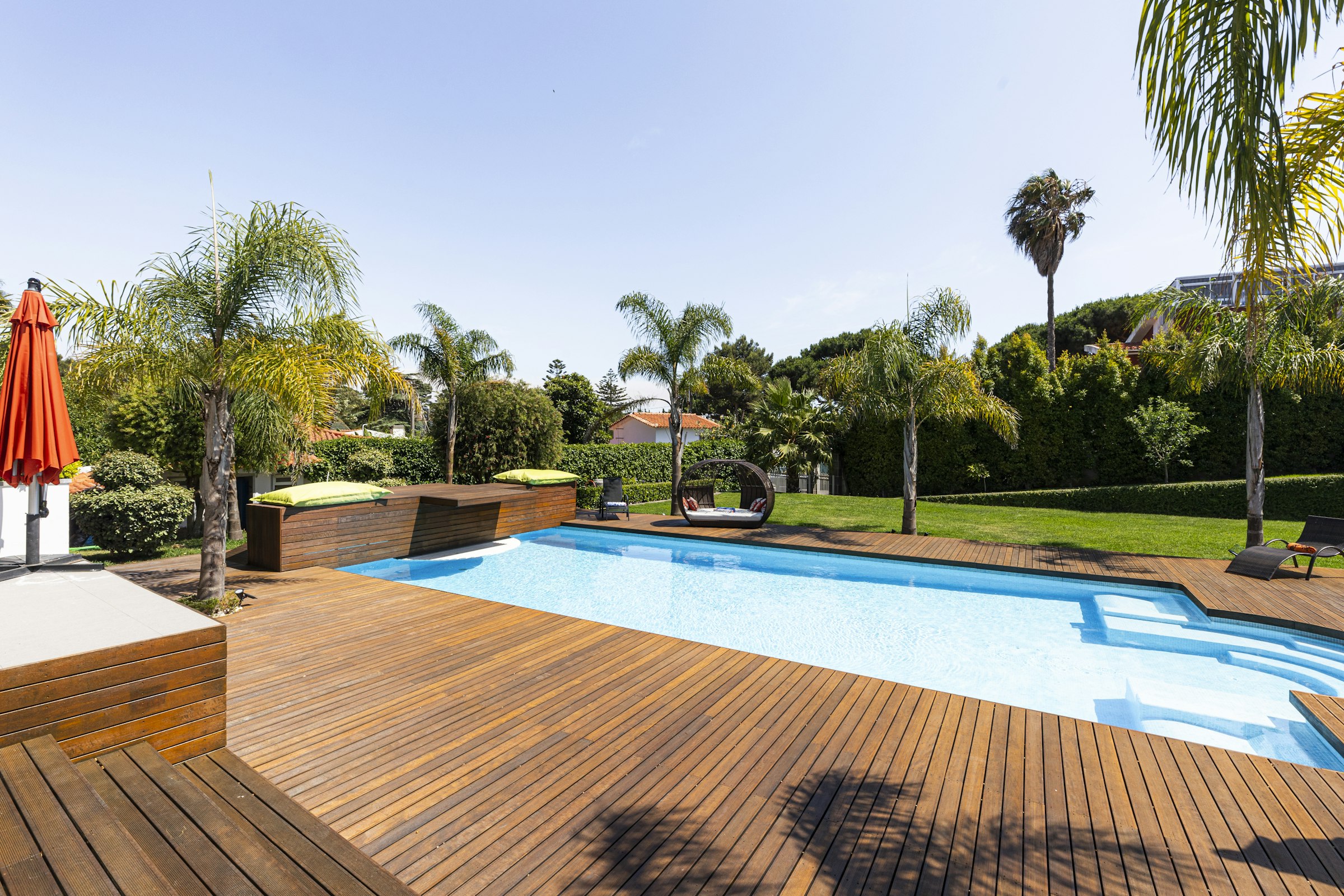 Deck de madeira com piscina e jardim